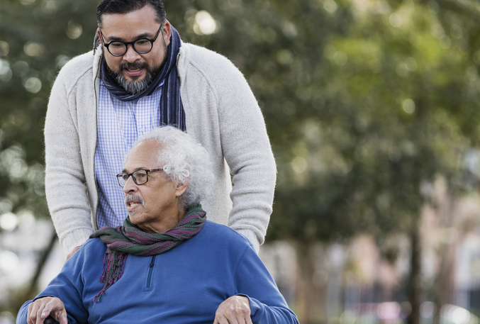 Senior Hispanic man in wheelchair, with adult son
