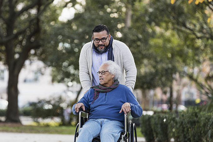 Senior Hispanic man in wheelchair, with adult son